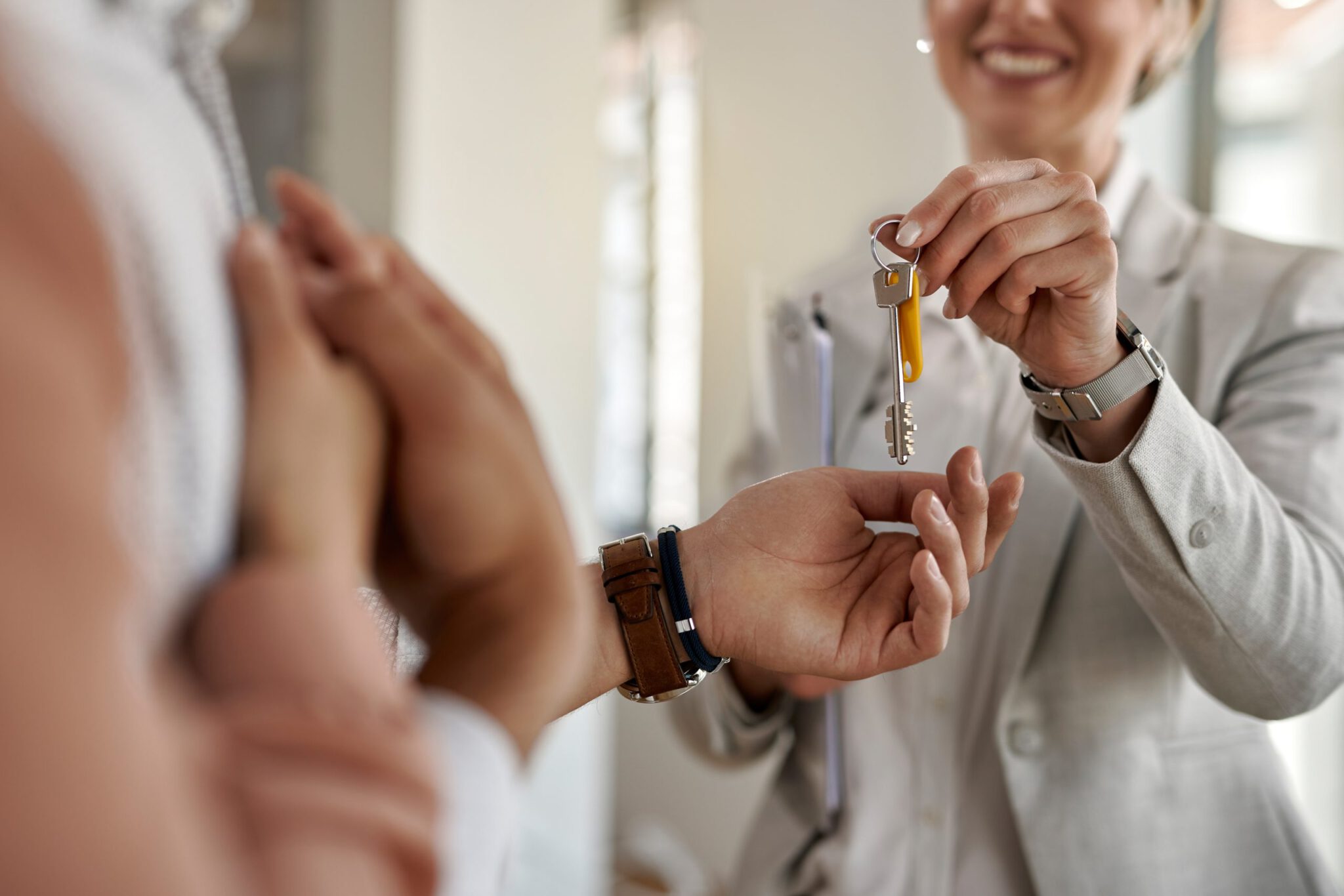 Vermarktung – Maklerin übergibt einem Paar die Schlüssel zur neuen Immobilie