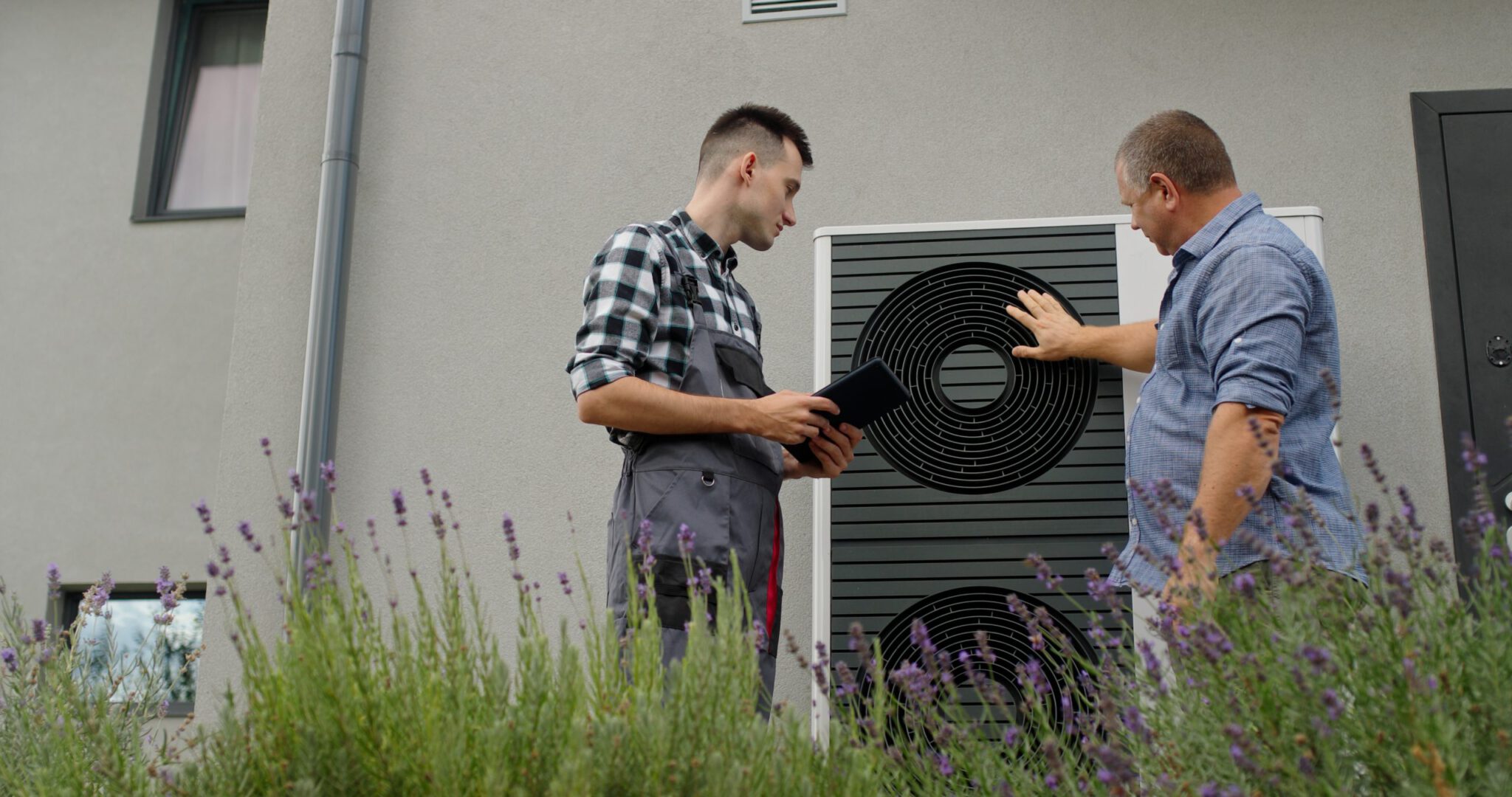 Energieberatung – Berater mit Tablet erklärt dem Eigentümer die Wärmepumpe vor Ort
