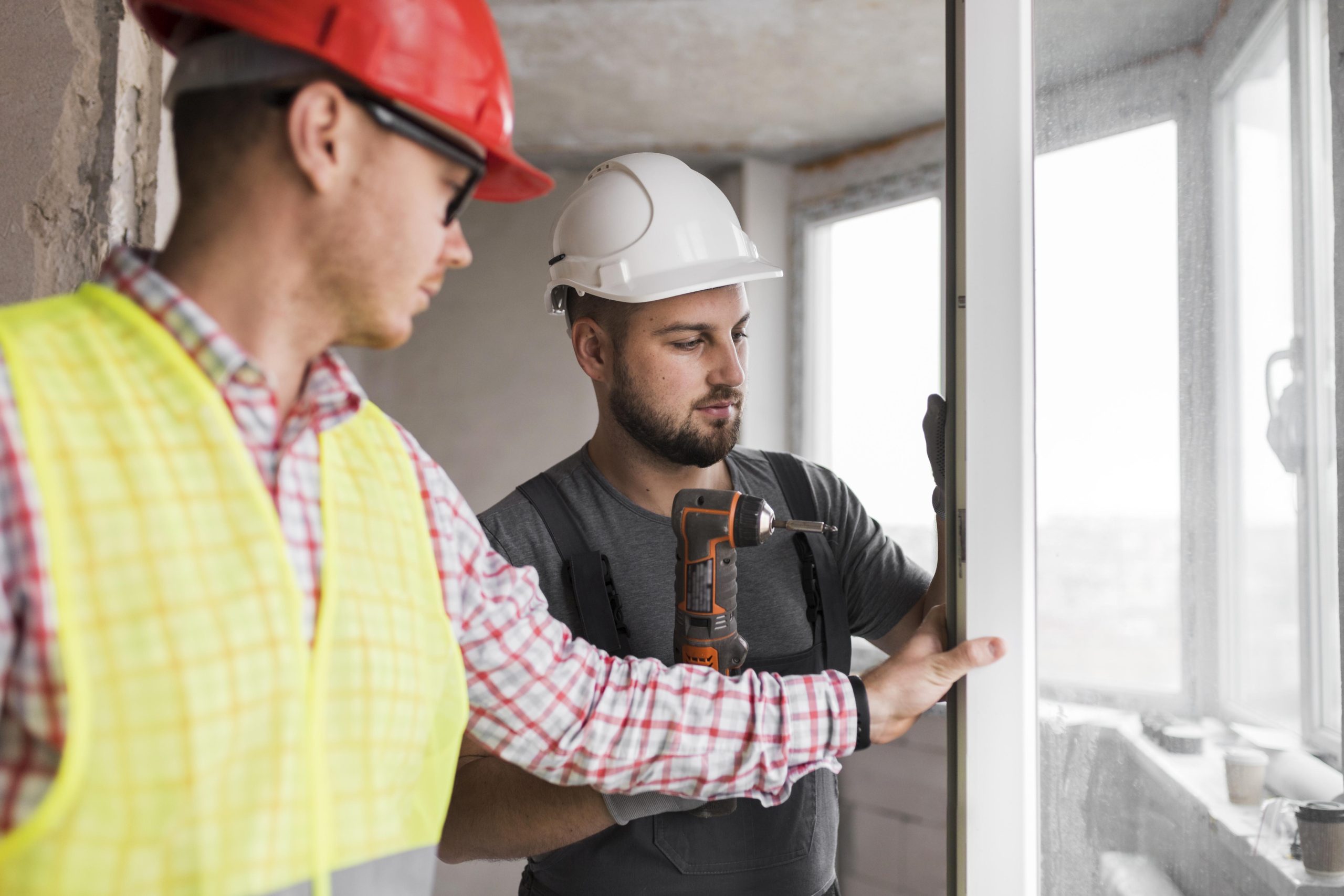Zwei Handwerker montieren gemeinsam ein Fenster
